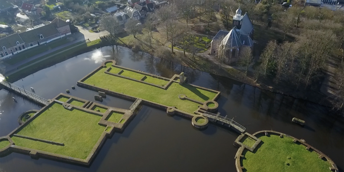 Luchtfoto van de fundamenten van kasteel Egmond, met daarnaast de Slotkapel